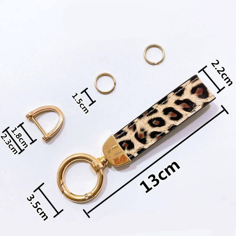 Llavero de cuero con estampado de serpiente leopardo y aro dividido dorado, adjunto a un llavero.