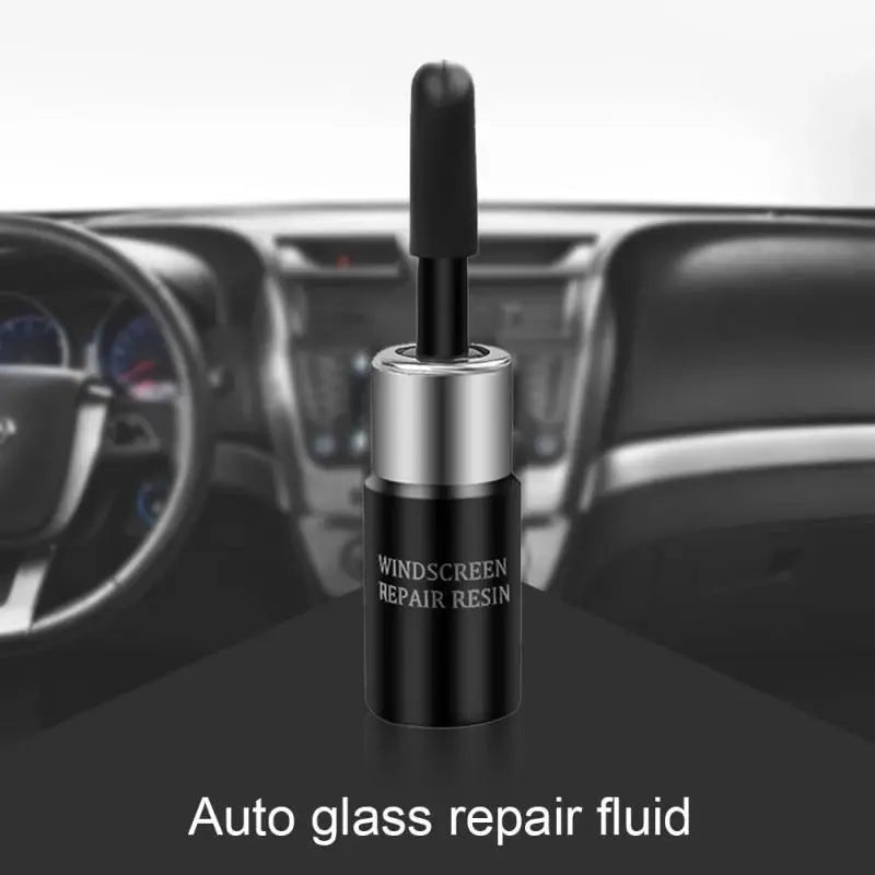 A black glass repair fluid bottle with a silver cap is shown on a dark car interior surface.
