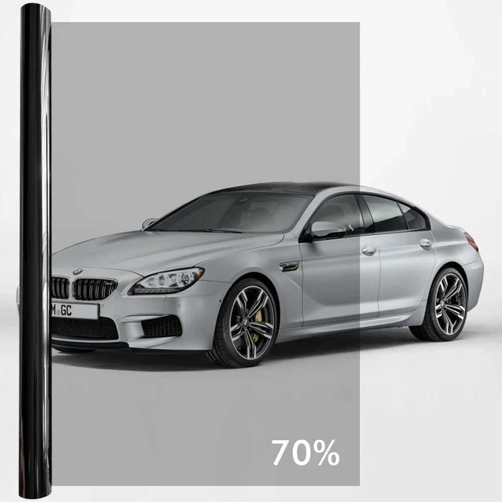 A silver BMW sedan with dark window privacy film installed, shown in a studio setting.