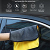 A yellow and gray microfiber car towel is shown being used to wipe a car window.