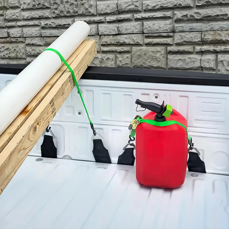 A red heavy-duty bed anchor is hanging on a wooden plank against a gray brick wall.