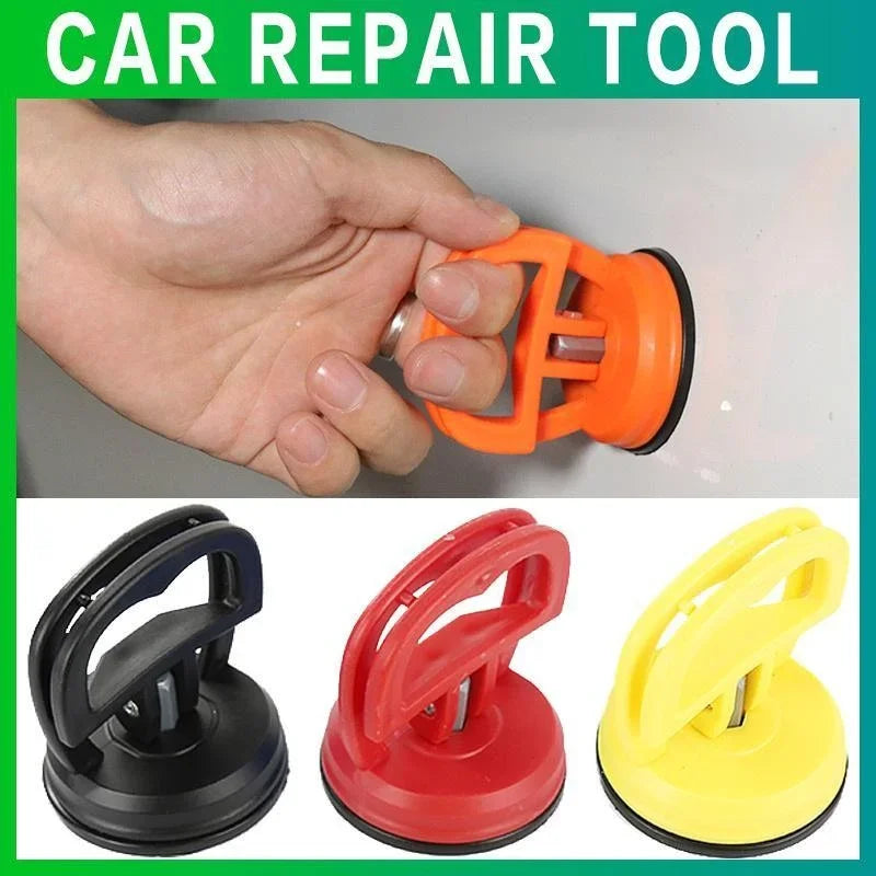 Une main tient un outil de réparation de voiture orange, montrant divers outils de tire-dents en plastique noir, rouge et jau