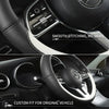 Close-up of a black steering wheel with custom fit leather covers and stitching details.