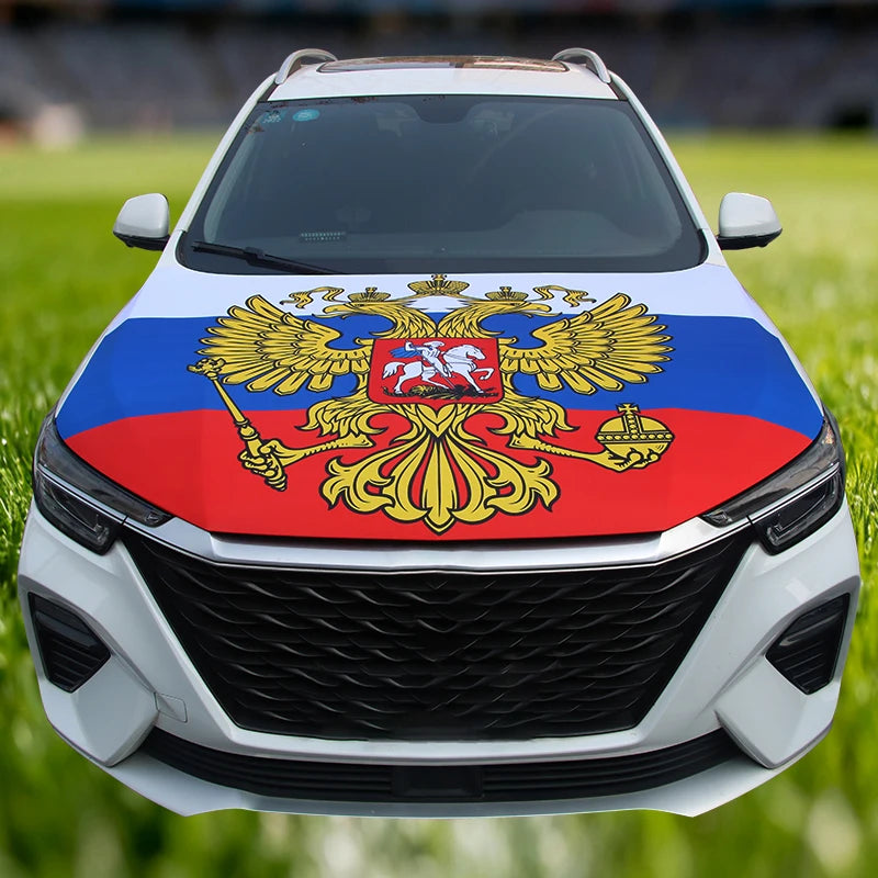 A white car hood decorated with a colorful flag featuring a golden eagle on a red background.