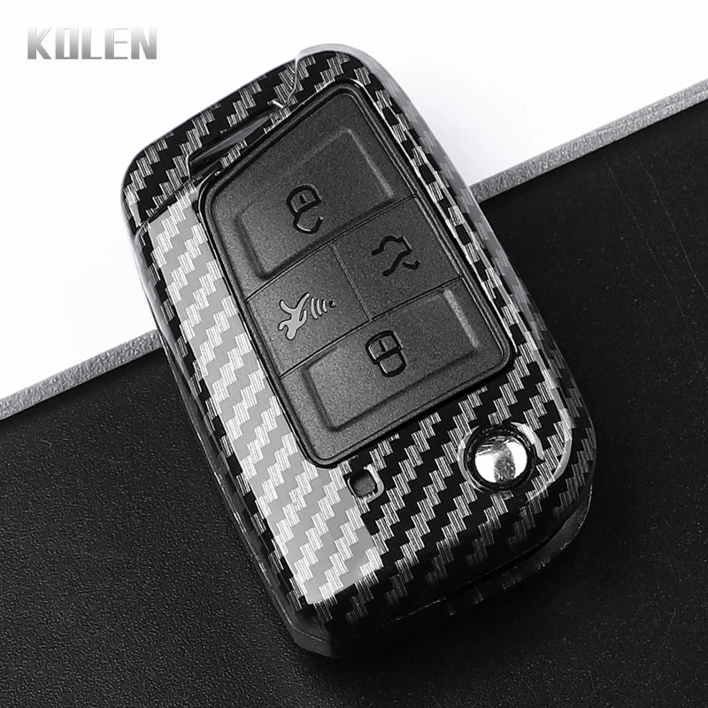 A black carbon fiber button cover for a car key, featuring embossed buttons.