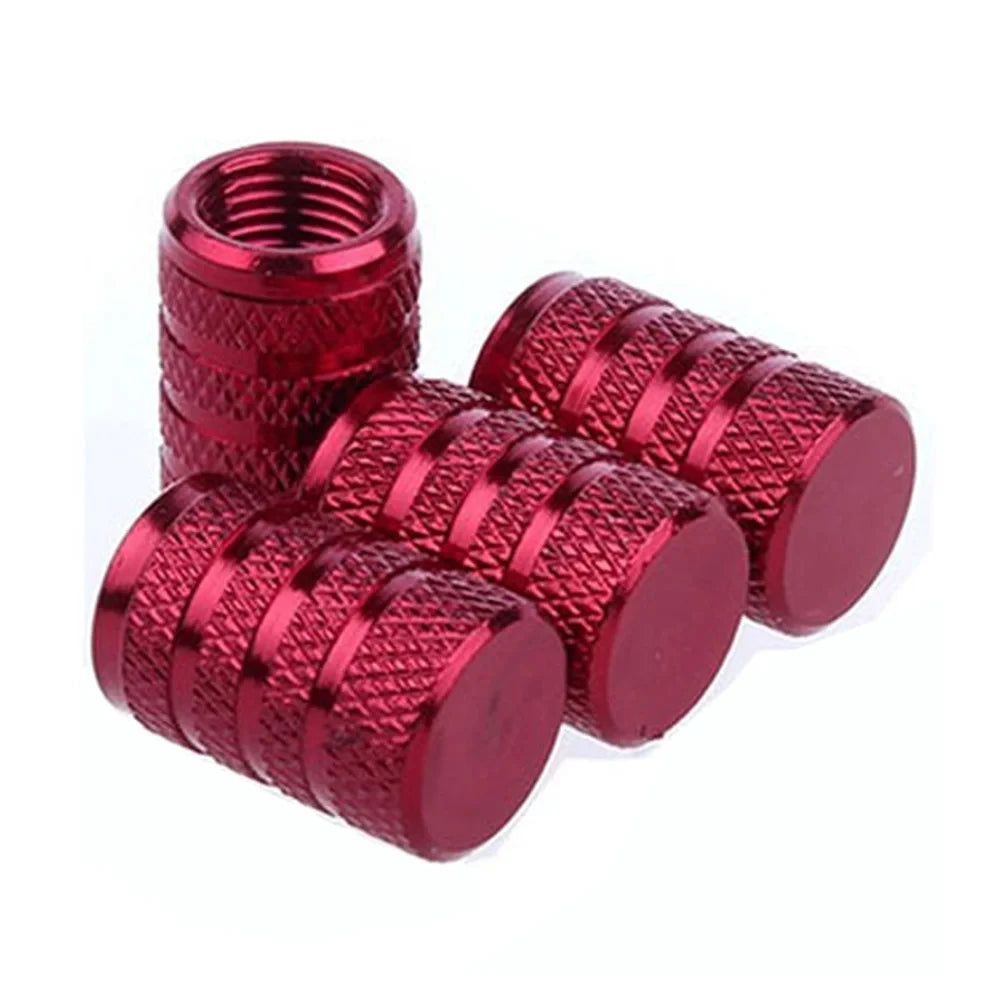A set of red aluminum tire valve caps with textured grips.
