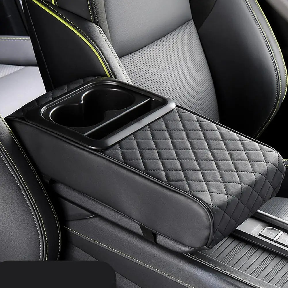 A black car armrest cushion with a diamond-quilted texture and an integrated cup holder is shown inside a vehicle interior.