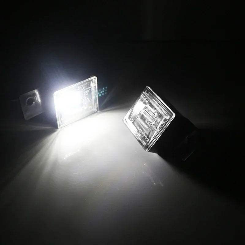 A close-up shot of a bright LED license plate light illuminating a dark surface.