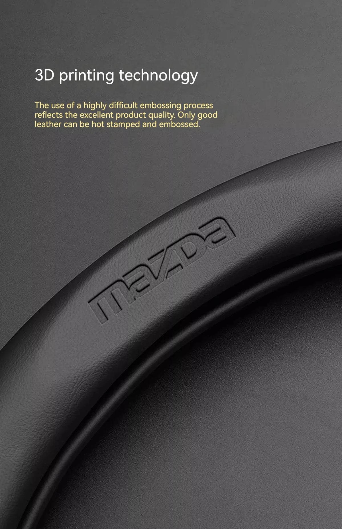 Gros plan d'une housse de volant en fibre de carbone noire mate avec le logo Mazda gravé.