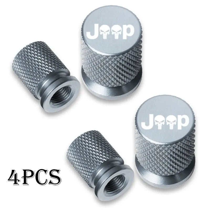 Four silver metal tire valve caps with Jeep logos and knurled texture
