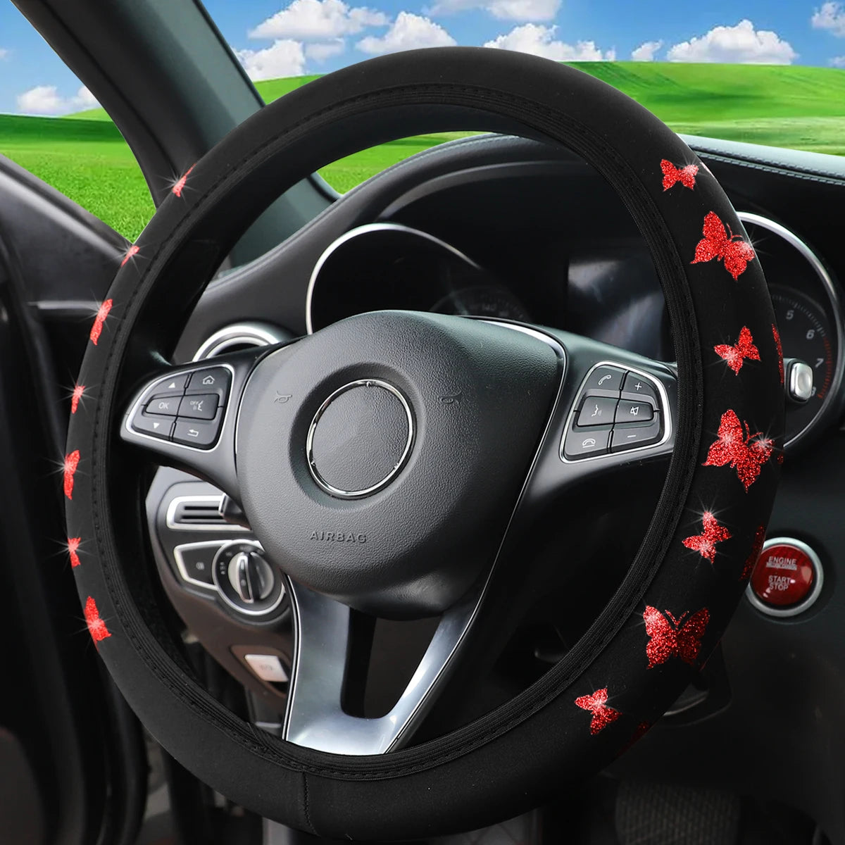 Black steering wheel with a glitter butterfly non-slip cover inside a car interior.