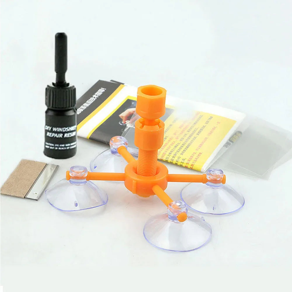 Orangefarbenes Scheibenreparaturset mit Kolben und mehreren klaren Glasreparationsscheiben neben der Verpackung