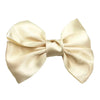 A cream-colored silk hair bow tied in a classic bow shape.