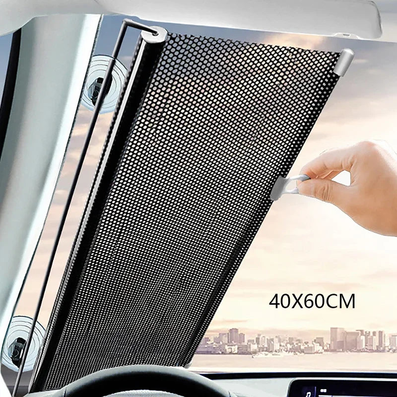A hand is adjusting a black mesh retractable car windshield sun shade in a vehicle interior.