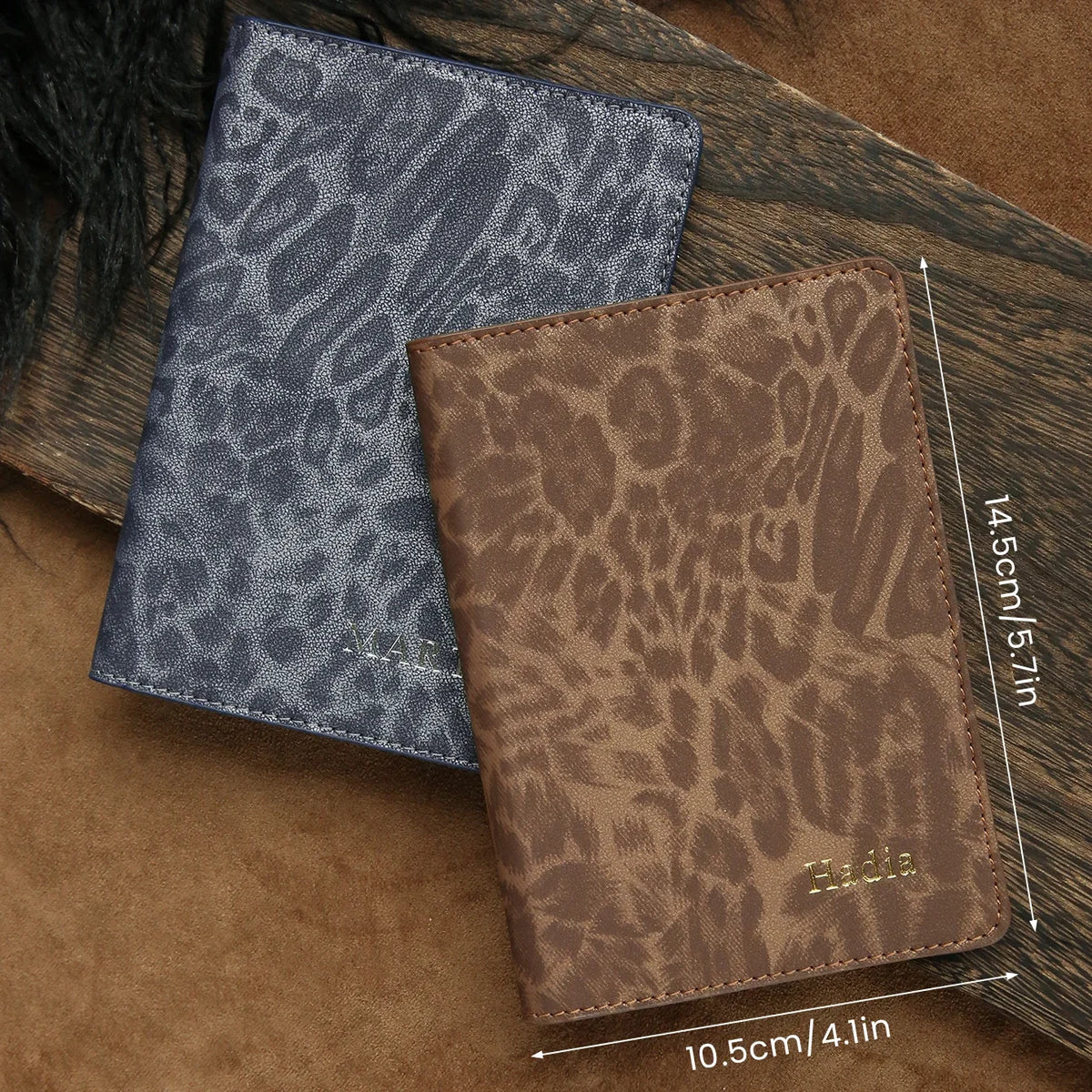 A pair of brown and blue leopard print passport holders resting on a wooden surface.