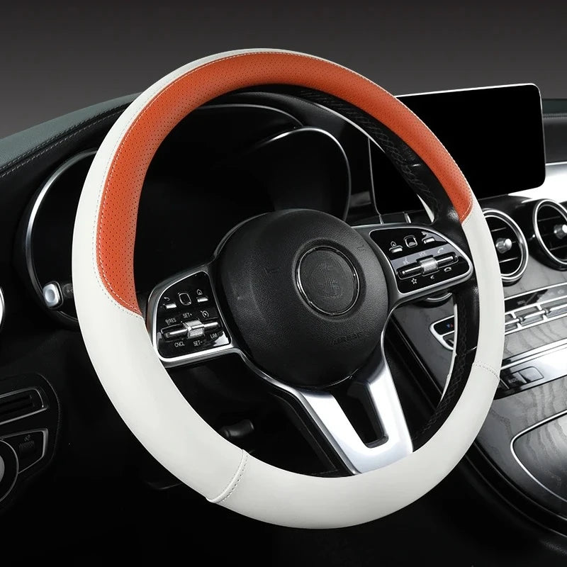 A close-up view of a white and orange perforated Nappa leather steering wheel cover inside a car interior.