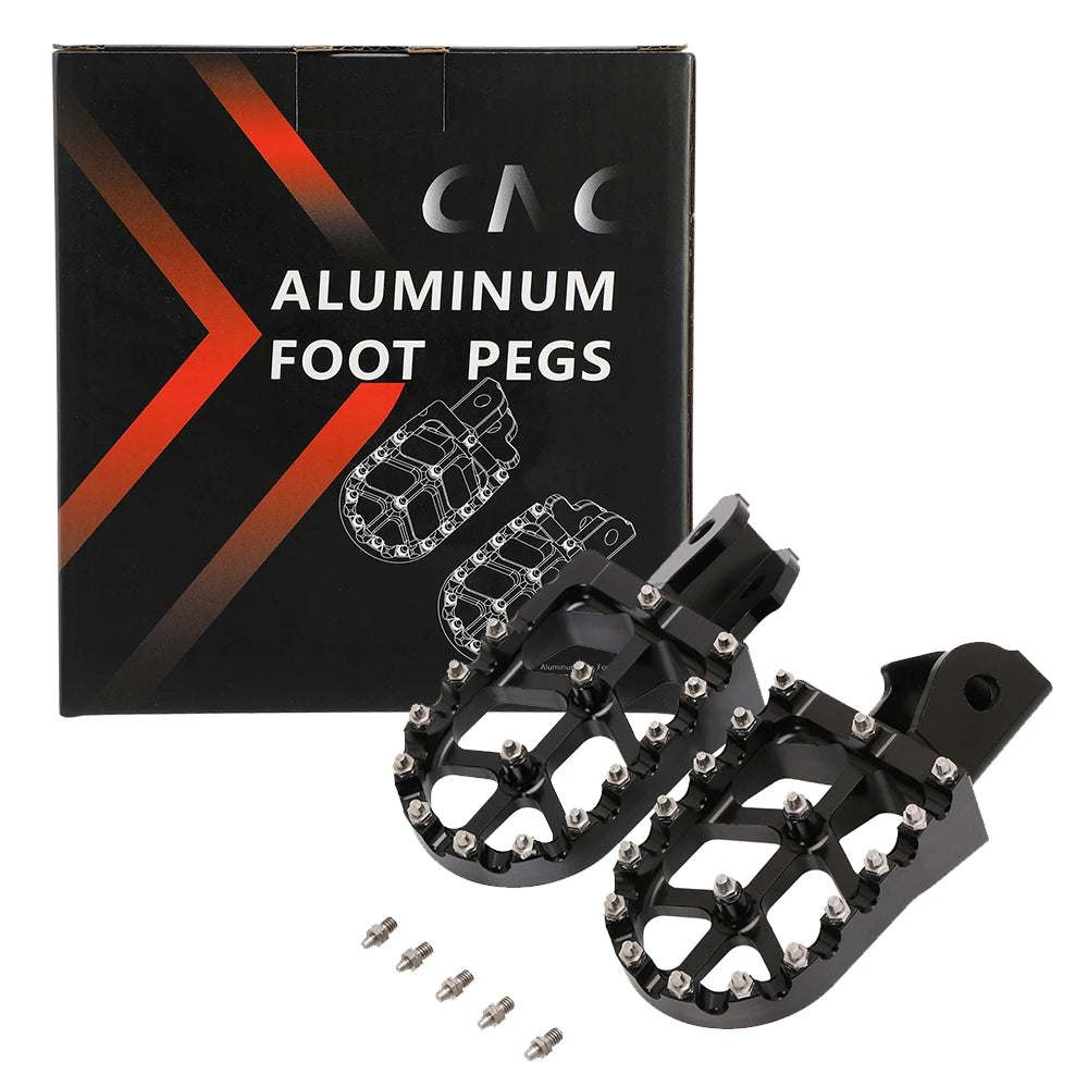 A black box containing aluminum foot pegs and several individual black metal foot pegs for motorcycles.