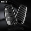 A black carbon fiber car key case cover with electronic features shown in a close-up view.