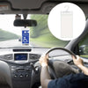 A hand is holding the steering wheel of a car while looking at a parking permit holder device mounted on the dashboard.