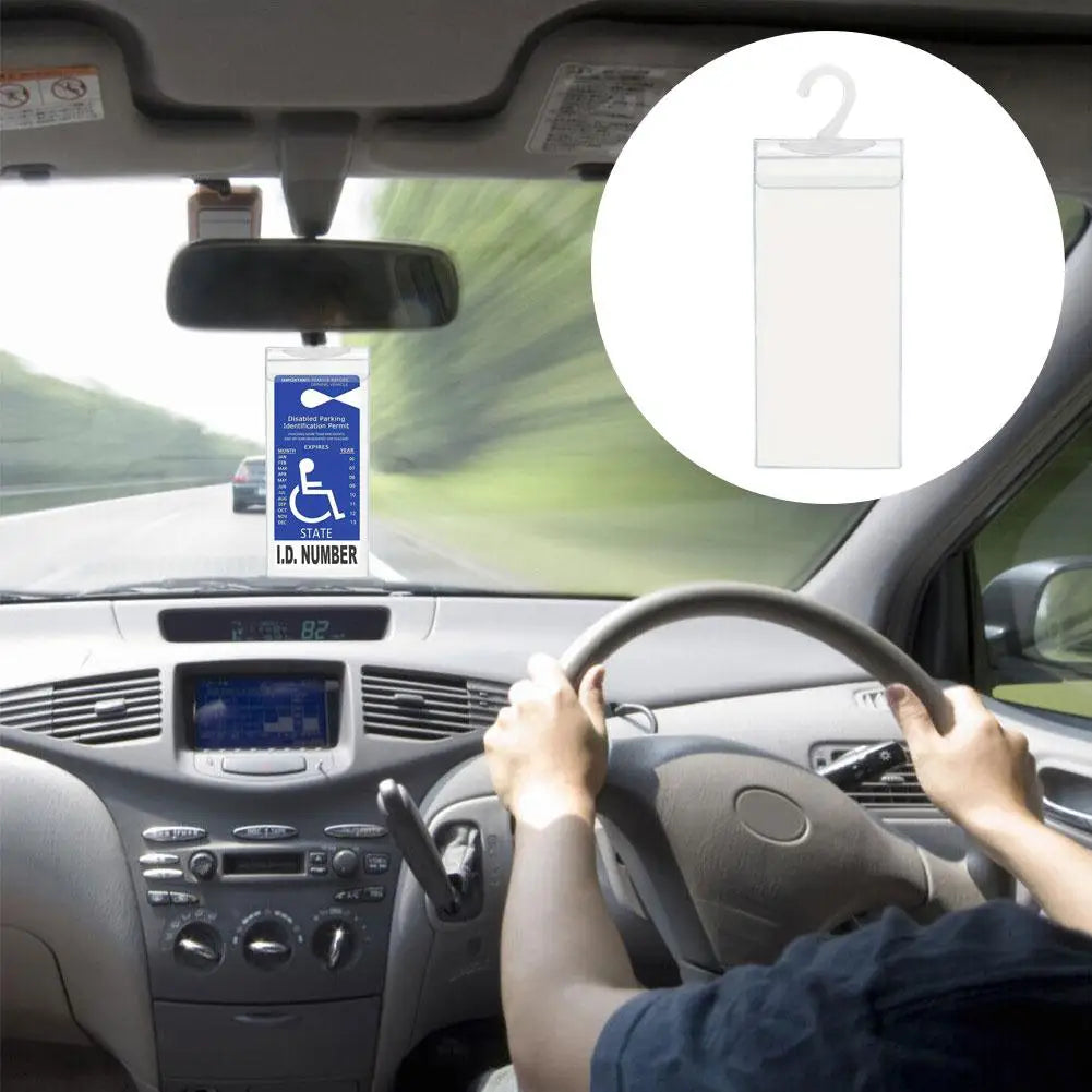 A hand is holding the steering wheel of a car while looking at a parking permit holder device mounted on the dashboard.