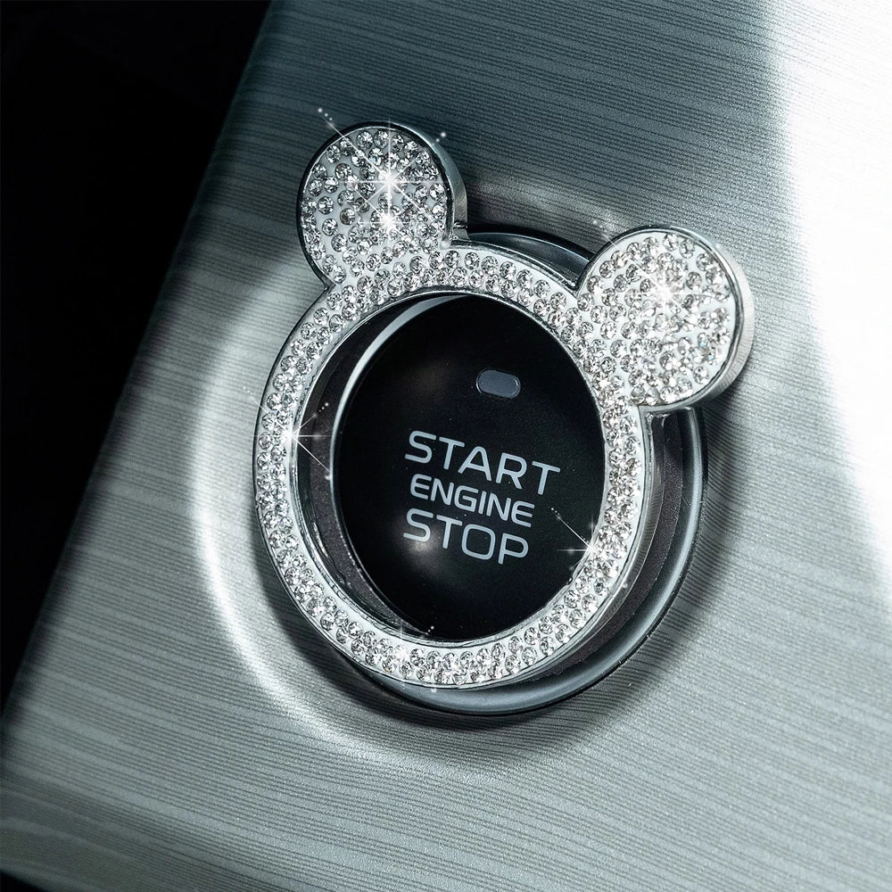 Primer plano de un tapón de encendido de strass brillante con forma de Mickey Mouse sobre una superficie de coche plateada.