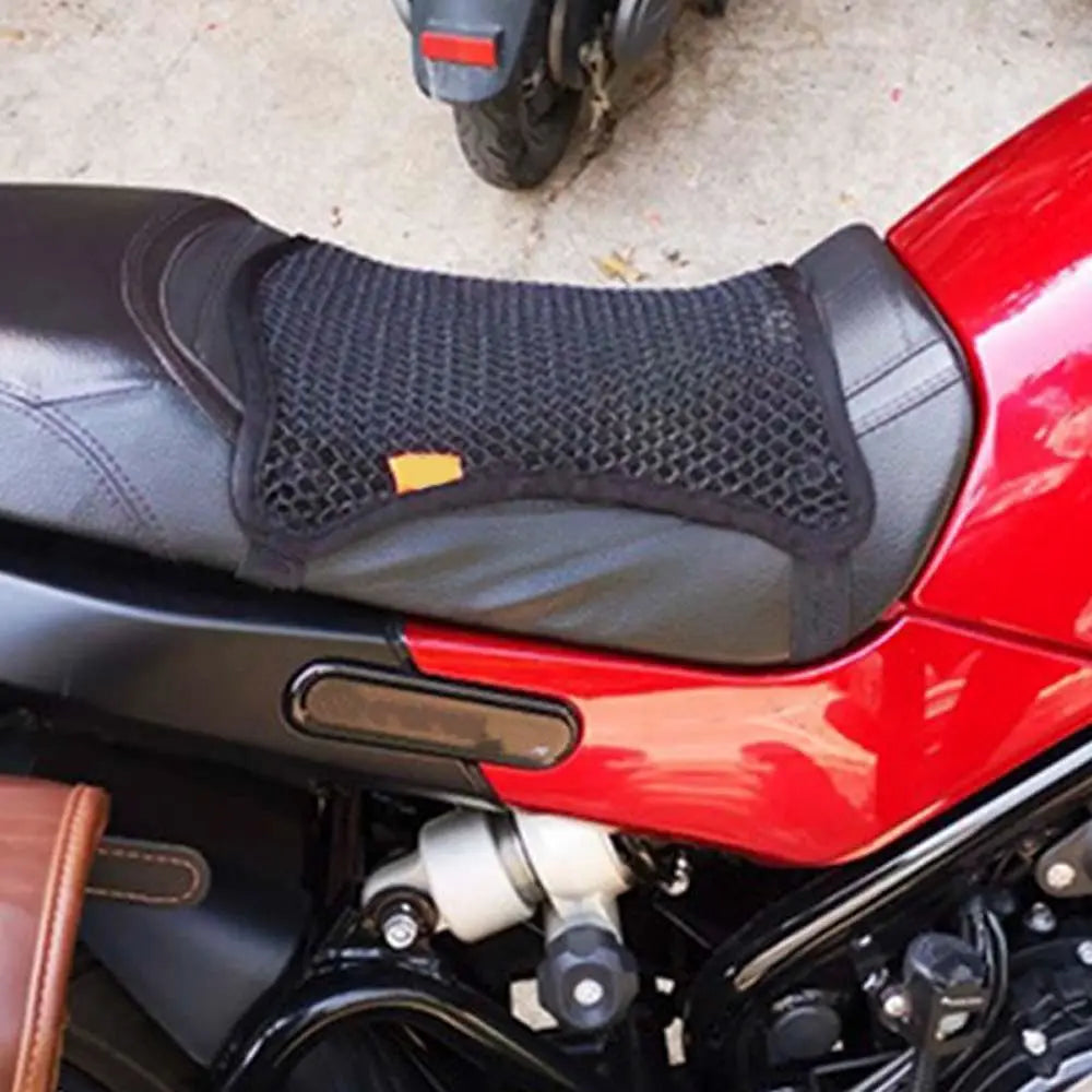 Close-up of a red motorcycle seat with a black mesh cushion cover installed.