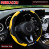 Yellow and black carbon fiber steering wheel cover installed in a car interior.