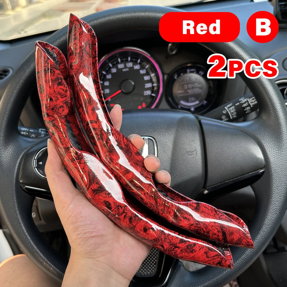 Two red and black universal car steering wheel booster covers are held in a hand inside a car interior.