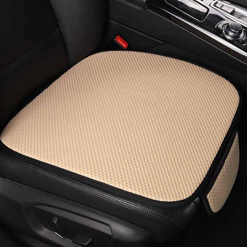 A beige breathable ice silk car seat cushion placed in a black car interior.