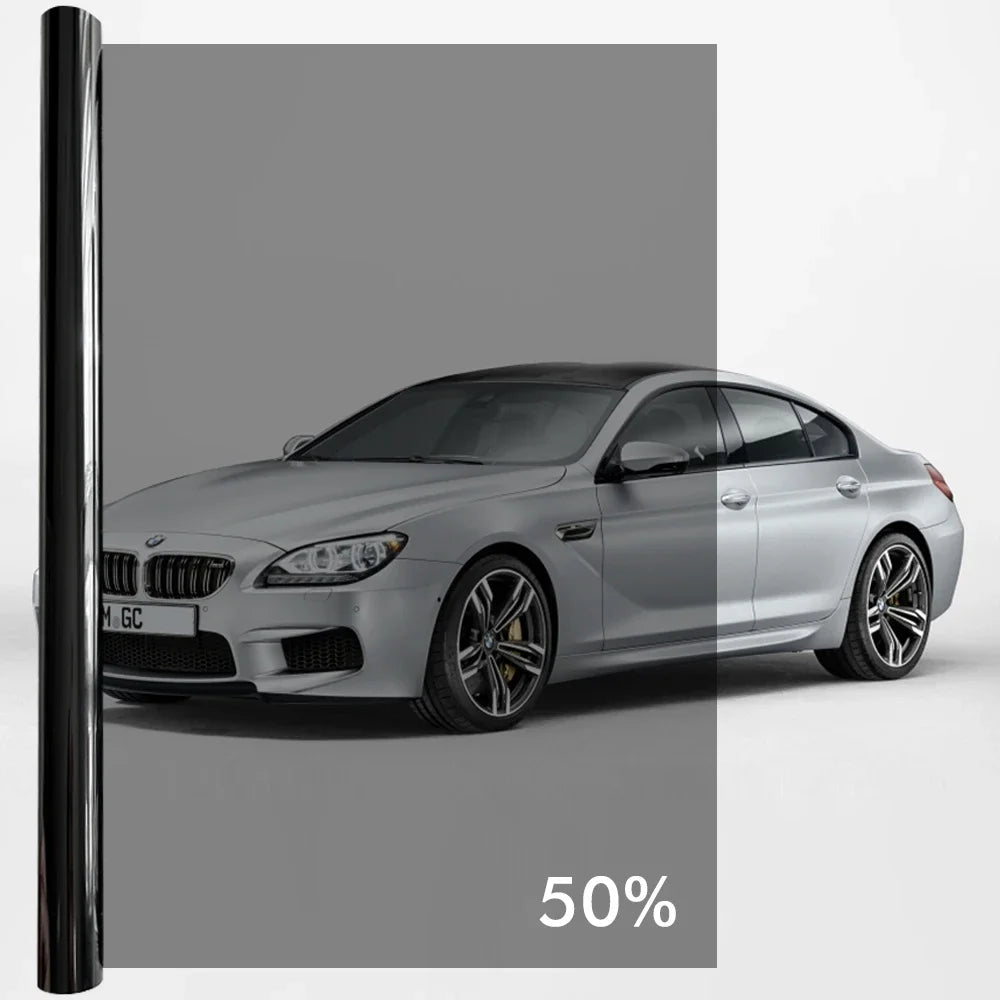 A silver BMW sedan with a dark tint window privacy film applied, shown in a studio setting.