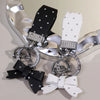 Luxuriöses PU-Leder-Fließ-Anhänger mit silberner Hardware und schwarz-weiß gemusterten Lederteilen.
