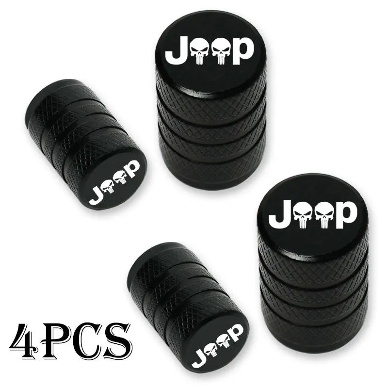 Four black Jeep branded tire valve caps stacked and laid out.