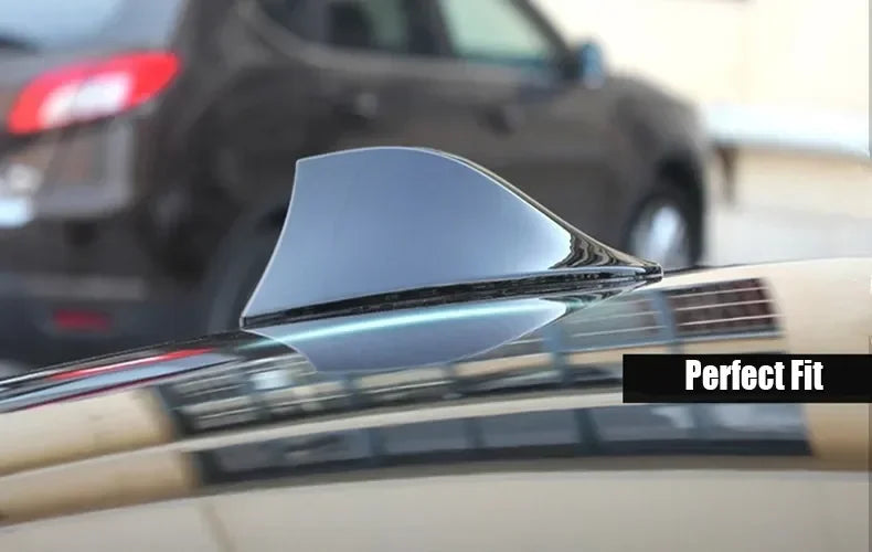 A close-up of a Shark Fin decorative car antenna cover perfectly fitted onto a vehicle's roof.