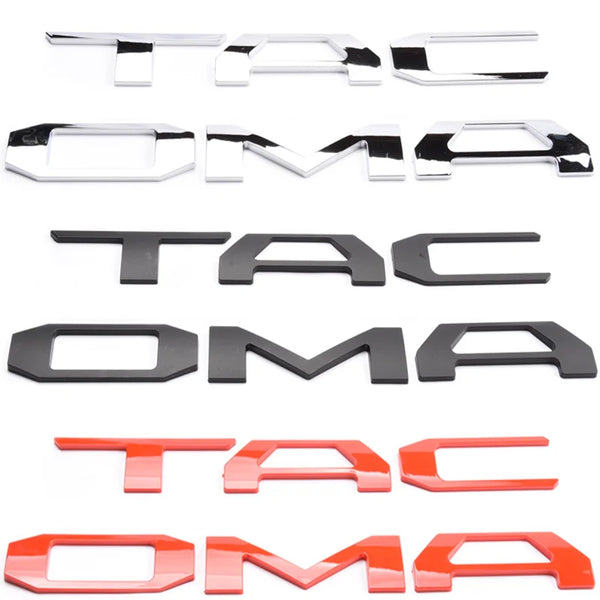 A set of 3D letter covers and emblems for a Toyota Tacoma tailgate in various colors including silver, black, and red.
