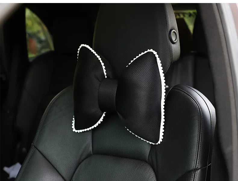 Black ergonomic car headrest pillow featuring a decorative bow design.