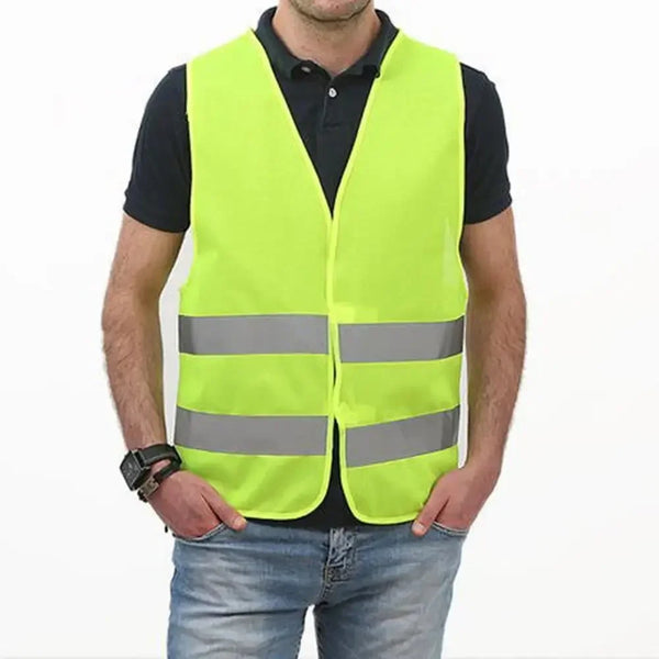 Un hombre vistiendo un chaleco reflectante amarillo brillante sobre una camisa negra y jeans.