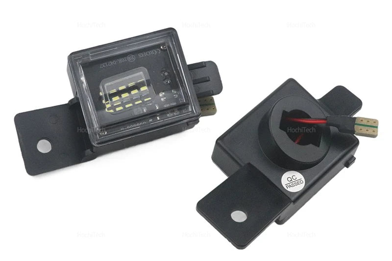 A black LED license plate light module with a clear lens and mounting bracket.
