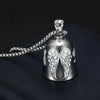 Silver angel guardian riding bell with detailed wings and a chain resting on a dark surface