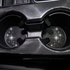 Close-up view of two textured black car cup coasters with diamond-like patterns.