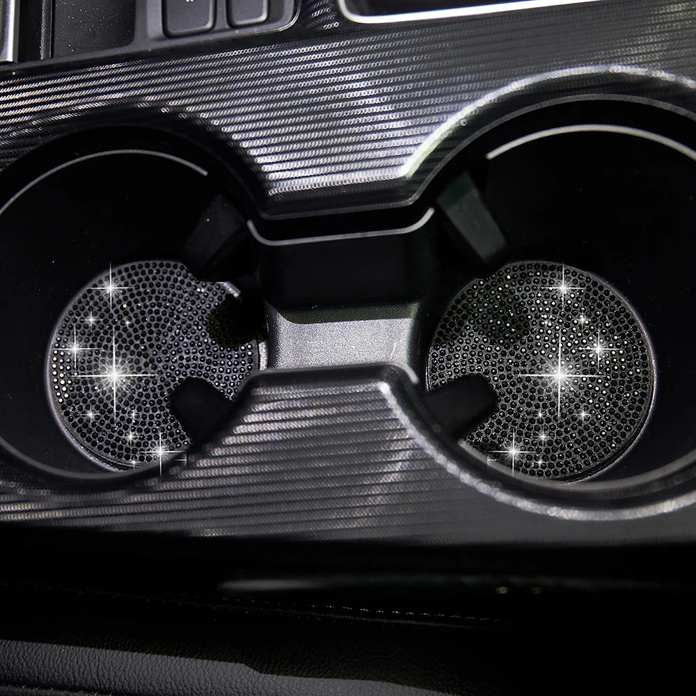 Close-up view of two textured black car cup coasters with diamond-like patterns.