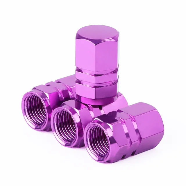 A set of four metallic purple hex aluminum alloy tire valve caps.