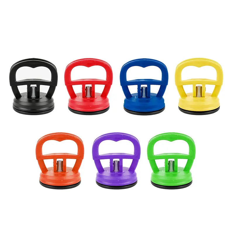 A set of five colored car dent remover pullers with suction cups and handles in black, red, blue, yellow, and green.