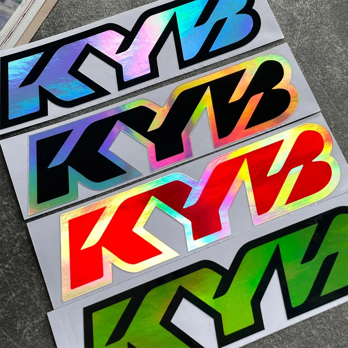 A set of black and pink racing suspension decals for motorcycles displayed on a gray surface.