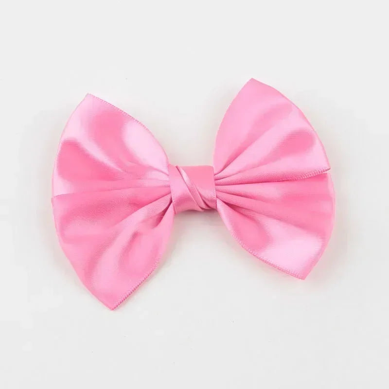 A pink silk hair bow tied in a classic bow shape.