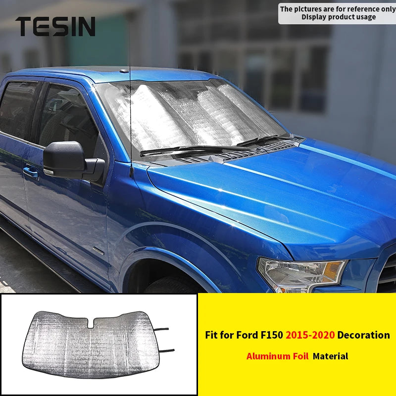 Aluminum foil windshield sunshade for a blue Ford F150 truck.