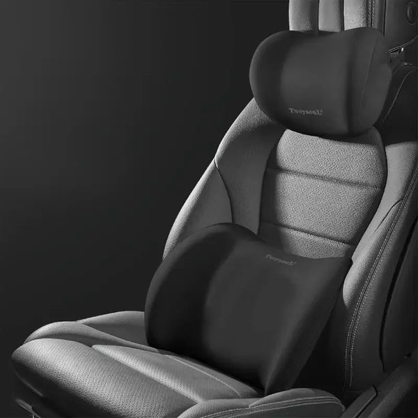 A close-up view of a gray ergonomic car headrest and lumbar support cushion inside a seat.