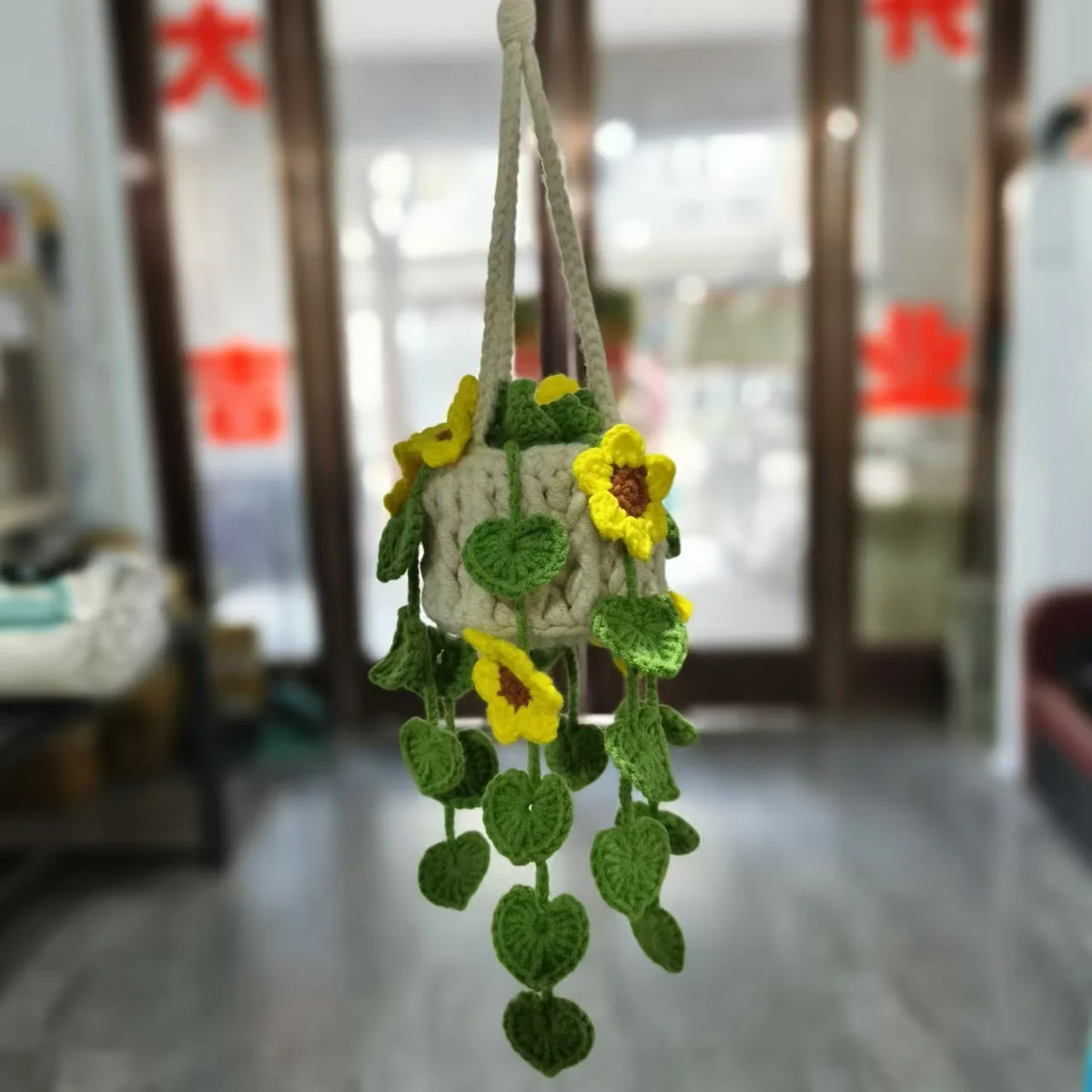 A handmade strawberry crochet hanging decor featuring yellow flowers and green leaves.