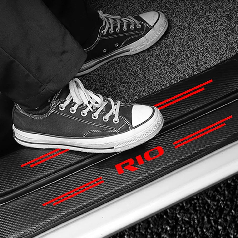 A pair of black canvas sneakers rests on a carbon fiber car door threshold decal with red markings.