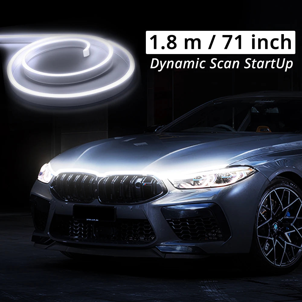 A close-up of a car's front grille and hood showing an LED light strip installation for a Dynamic Scan StartUp system.