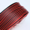 A close-up view of a black and red high flexibility LED power cord coiled on a transparent surface.